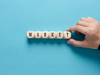 Business market concept. Male hand arranges the wooden cubes with the word market.