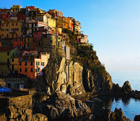 Fototapeta na wymiar View of small village built on the rocks. Manarola. Village between mountains and the Ligurian sea. Famous touristic place and travel destination in Italy. The Cinque Terre. UNESCO World Heritage Site