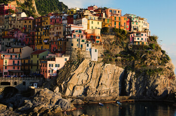 Fototapeta na wymiar Small village built on the rocks. Manarola. Village between mountains and the Ligurian sea. Famous touristic place and travel destination in Italy. The Cinque Terre. UNESCO World Heritage Site