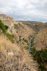 View of Gravina river canyon and park of the Rupestrian Churches of Matera with houses in caves di Murgia Timone near ancient town Matera (Sassi), , Basilicata,  Italy