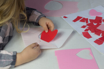 Child holding letter with red paper heart,love letter for Valentine's day,gift for Mothers...