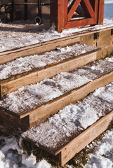 Fototapeta na wymiar Wooden stairs covered with snow and ice.