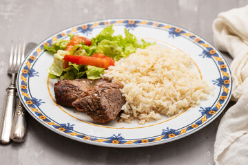 Baked fried meat with boiled rice and fresh salad