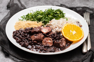 black beans stew with sausages on a white dish