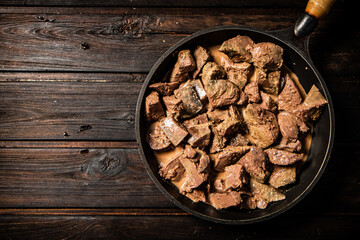 Liver fried in a frying pan. 