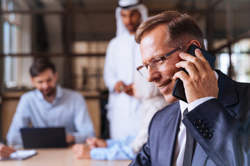 Multiracial group of corporate businesspeople working in a business office - Multiethnic businessmen and businesswomen meeting in the office in Dubai, UAE