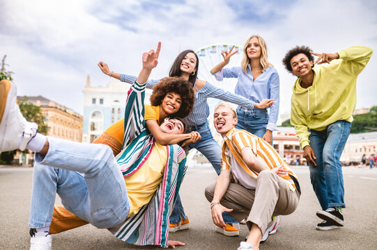 Multiracial young people together meeting and social gathering - Group of friends with mixed races having fun outdoors in the city- Friendship and lifestyle concepts