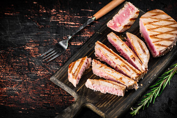 Grilled tuna on a cutting board.