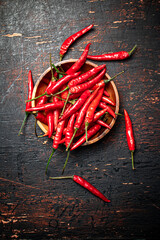 Wooden plate with hot chili peppers. 