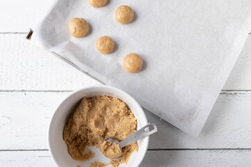 Fresh dough for making gingerbread cookies on white background in a bowl with baking sheet