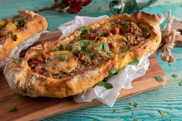 Turkish pide with ground beef and cheese topping