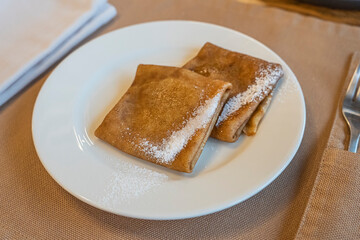 Pancakes are stacked on white plate top view