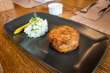 potato pancake draniki and white sour cream sauce on plate. veggie fritters vegetarian pancakes...