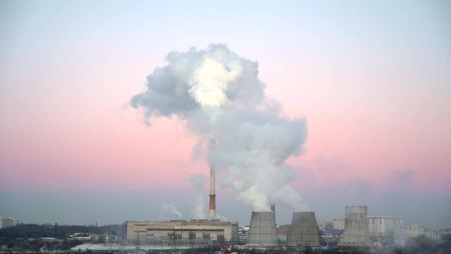 Thermal power station on sunset with thick white smoke from the pipes in severe frost