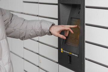 Shopping locker inPost with man's hand entering code to open it. E-commerce shipping and delivery...