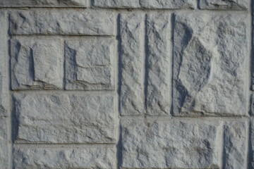 Macro of gray concrete brick veneer wall with random layout