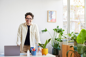 Smiling man with netbook in modern studio