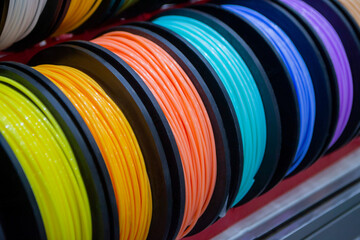 Many multi-colored spools of thread of filament for printing 3d printer. Material coils for printing 3D printer. Spools of 3D printing motley different colors filament. ABS wire plastic for 3d printer - obrazy, fototapety, plakaty