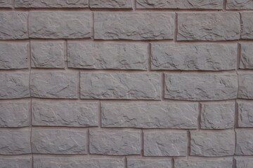 Surface of grayish pink painted brick veneer wall