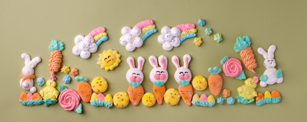 Fototapeta na wymiar Sweets, pastry, gingerbread cookies for Easter table. Easter rabbit bunny, tender rainbow on green background top view copy space, spring seasonal holiday banner for your site, flyer, coupon
