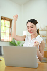 Obraz premium Cheerful and joyful Asian woman dancing, moving hands while listening to music