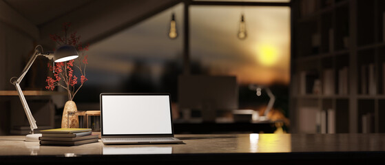 Laptop mockup, decor, and table lamp on tabletop over blurred background of modern home office