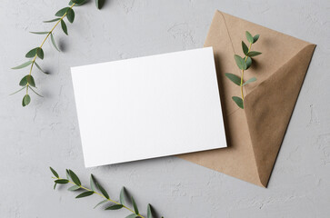 Wedding invitation or blank greeting card mockup with eucalyptus twigs and envelope