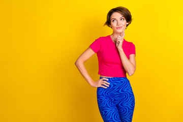 Photo of positive thoughtful woman dressed pink t-shirt finger chin looking empty space isolated yellow color background