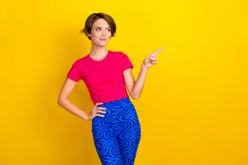 Photo of thoughtful dreamy woman dressed pink t-shirt looking pointing empty space isolated yellow color background