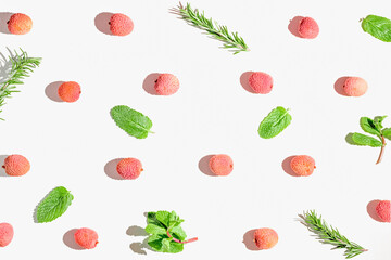 Fresh lychee fruits with rosemary and mint leaves on white background. Minimal style composition. Healthy food concept. Summer refreshment theme