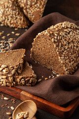 Fresh homemade bread with seeds on a warm background. Vertical photo