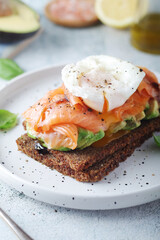 A rye bread sandwich with avocado and salmon