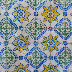 Damaged, dirty, not corrected, vintage azulejos, glazed ceramic tiles with blue ornaments on building wall. Heritage Concept of traditional Portuguese art.