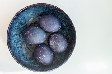 Deep Blue easter eggs in a bowl. Top view