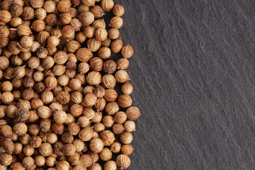 coriander seeds lie on a stone gray board