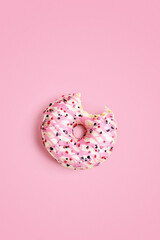 Sweet bitten donut on pink background. Color card .