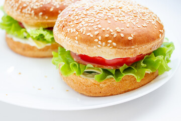 Sandwich with ham, cheese and lettuce in a sesame bun.