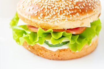 Burger with lettuce and sesame seed bun.