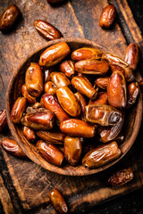 Dates in a plate on a cutting board. 