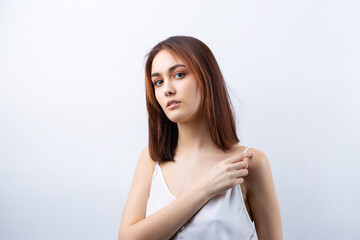 Naklejka premium Beautiful smiling woman with clean skin, natural make-up and white teeth on a gray background