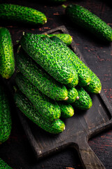 Fresh cucumbers on a wooden cutting board. 