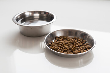 Cat food and water in metallic bowls