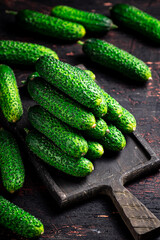 Fresh cucumbers on a wooden cutting board. 