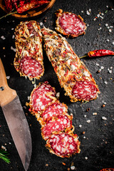 Pieces of salami with pods of dried chili peppers. 