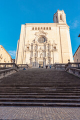 Fototapeta na wymiar catedral de la ciudad de gerona con todos los largos escalones para llegar a su puerta bajo un cielo azul soleado.