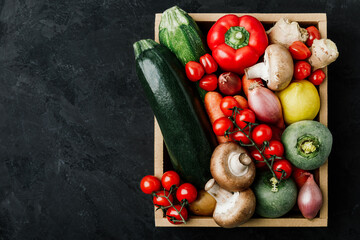 Fresh vegetables wooden box. Organic zucchini, tomatoes, potatoes, paprika, onions, carrots, mushrooms in wooden box.