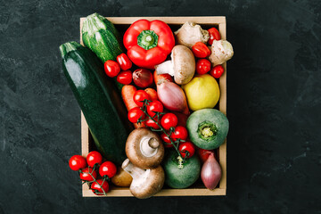 Fresh vegetables wooden box. Organic zucchini, tomatoes, potatoes, paprika, onions, carrots, mushrooms in wooden box.