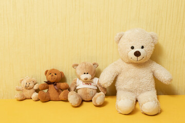 Four teddy bears sit on the bed