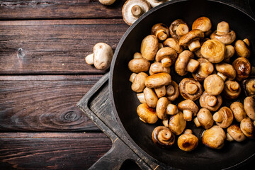 Fragrant homemade fried mushrooms in a frying pan on a cutting board. 