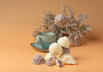 coconut cookies on a green dish with a cup of coffee on an orange background with flying coffees